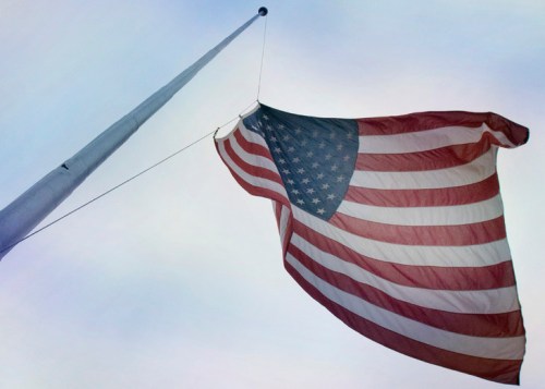 The American Flag being raised at Penn State's Old Main lawn.
